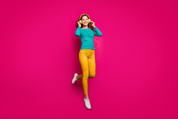 Fototapeta na wymiar Full length body size photo of cheerful positive nice pretty cute charming girlfriend wearing yellow pants trousers white footwear smiling toothily isolated jumping over vivid pink color background