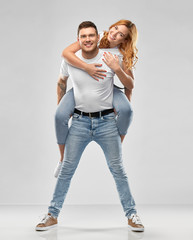relationships and people concept - portrait of happy couple in white t-shirts having fun over grey...