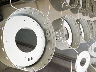 Powder coating line. Metal panels are suspended on an overhead conveyor line. Painting products in...