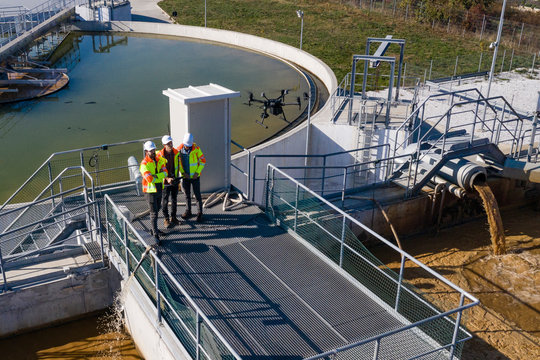 Engineers Assesing Waste Treatment Plant With Drone