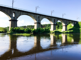 Fototapeta na wymiar Stone bridge across the river on a sunny day