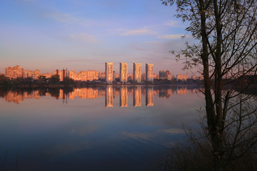 Fototapeta na wymiar Reflection of houses at sunset in the lake