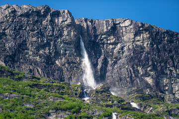 Vinnufallet in summer sunlight, flushing down a steep mountainside in Norway