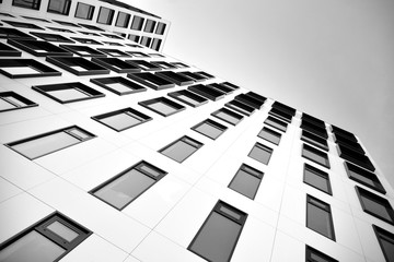 Modern European building. White building with many windows against the blue sky. Abstract architecture, fragment of modern urban geometry. Black and white.