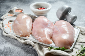 Raw Turkey Breasts on a white chopping Board. Organic farm bird. Fresh fillet. Gray background