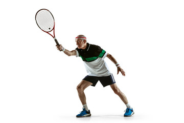 Senior man wearing sportwear playing tennis isolated on white background. Caucasian male model in great shape stays active and sportive. Concept of sport, activity, movement, wellbeing. Copyspace, ad.