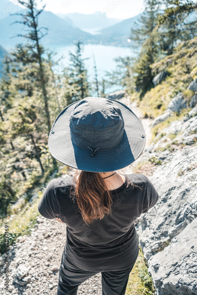 Wall mural female hiker descending from mount schoberstein and looking down to the lake atter (attersee) in the