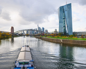 River transport by barge in Frankfurt am Main with the skyscrapers in the background - obrazy, fototapety, plakaty