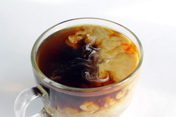  Coffee with milk in a glass transparent cup.