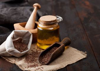 Linen bag of raw natural organic linseed flax-seed with spoon and oil on wooden background. Healthy...