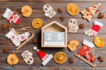 Top view of calendar on Christmas wooden background. The twenty fifth of December. New Year toys and decorations. Holiday concept