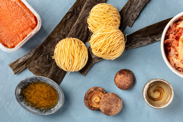 Ramen ingredients. Dried sea vegetable kelp, soba noodles, miso paste, bonito tuna flakes, shiitake mushrooms, sake, mirin, overhead shot, a flat lay composition