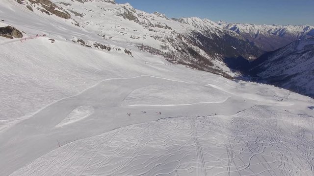 Snowy Ski Resort in Alps. Beautiful drone footage of professional Swiss skiers in the alpine region of Ticino.