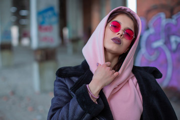 Fashionable cool girl in a powdery hoodie and glasses