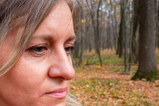 Closeup Of Middle Aged Woman Face With Gray Eyes. Real Skin Without Make Up And Correction. Do Not Look At Camera. No Smile