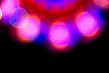 Defocused of photo bokeh blurred circle light from colorful neon lighting bulb in the night for abstract background texture pattern