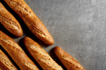 Homemade cakes. Freshly baked baguettes on a gray stone surface. Top view.