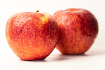 Couple red apple with drops isolated on white.