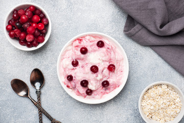 Cottage cheese dessert of yogurt jam and cranberries on a plate. grey concrete table. Concept healthy useful Breakfast. Copy space.