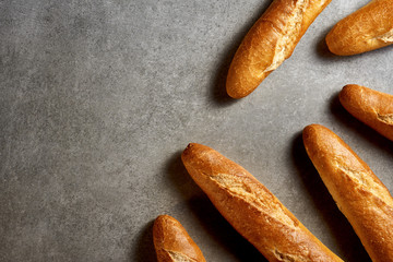 Fresh pastries. Baguettes on a gray stone surface. Top view.