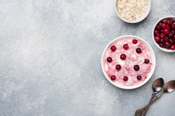Cottage cheese dessert of yogurt jam and cranberries on a plate. grey concrete table. Concept healthy useful Breakfast. Copy space.