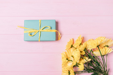 Blue gift box and bouquet of fresh yellow flowers
