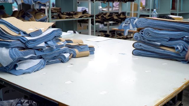 The worker of the sewing factory collects pieces of fabric cut by the automatic laser machine into sets. 4k footage.