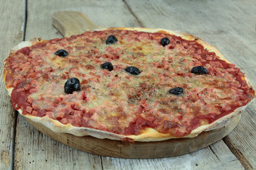 pizza with ham and mozzarella on a wooden table