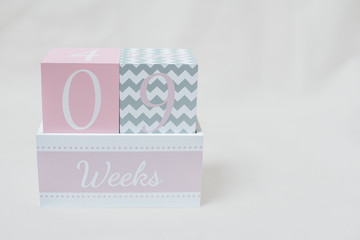 Rosa grauer Wochenwürfel 9 Wochen 9 weeks vor weißem Hintergrund