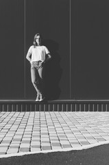 Black and white shot of Beautiful Woman against grey wall with Banana in the pocket of jeans