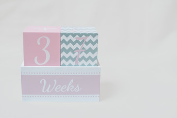 Rosa grauer Wochenwürfel 37 Wochen 37 weeks vor weißem Hintergrund