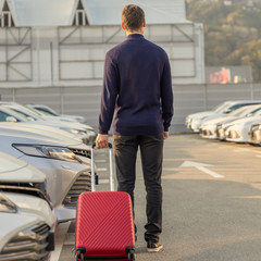 A dealership customer walking through a row of rental cars to his vehicle The view from the back