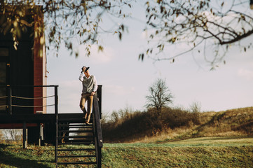man in a hat on a background of a wooden house. nature in the background