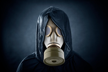 Man in a gas mask and hooded cloak. Environment pollution.