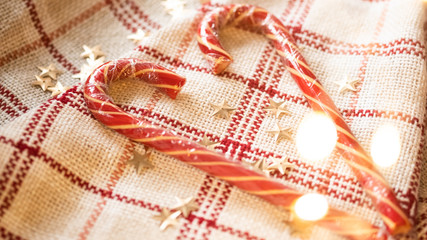 Candy Canes in the shape of a heart. Cozy new year. Christmas card with christmas lights and decorations. Selective focus. Christmas background. Valentine's Day