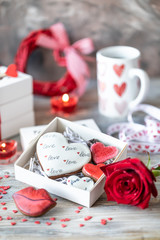 Cookies or gingerbread cookies in a gift box with a red ribbon on a wooden table. Valentine's Day.