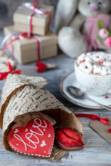 Cookies or gingerbread cookies in a gift box with a red ribbon on a wooden table. Valentine's Day.