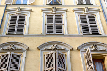 Fototapeta premium detail of typical French building. Yellow with faded shutters in Antibes, cote d'azur or the French Riviera