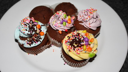 Close up view of various sweet cupcakes, selectively focused, against a bokeh background