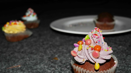 Close up view of various sweet cupcakes, selectively focused, against a bokeh background