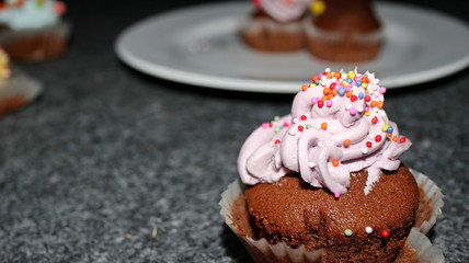 Close up view of various sweet cupcakes, selectively focused, against a bokeh background