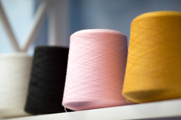 Multicolored threads, skeins and tangles of Italian wool yarn, knitting needles. Atelier sewing accessories, Knitting skein of pink, black and yellow wool.