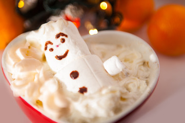 Marshmallows snowman in read heart bowl. Christmas conception