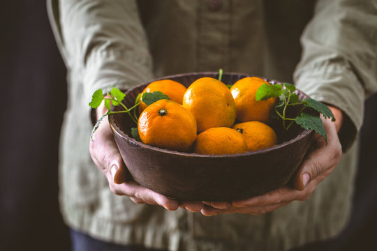 Fresh tangerine in hands