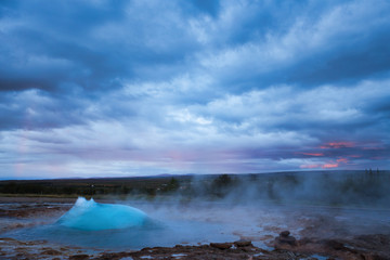 Strokkur Geysir Eruption with Dark Cloudy Sky, Iceland