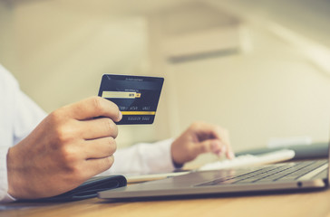 Online shopping, A young man holds a credit card to make payments via the internet, Credit card payment