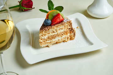 Famous traditional Kiev cake (Hazelnut Daquoise cake) on a white plate. Tasty meringue layers and vanilla buttercream dessert. Food flat lay with desset