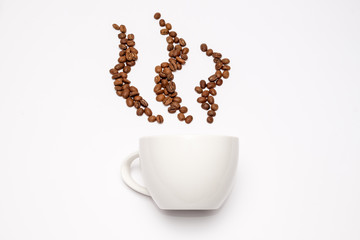 Coffee beans arrange as vapor above the cup on white background