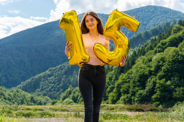 Teen girl with golden balloons 15th celebrating her birthday