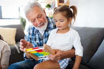 Cute little girl playing with her grandfather at home. Happy family concept